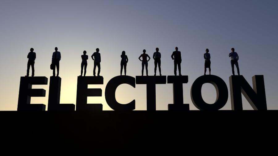 people standing on letters spelling election