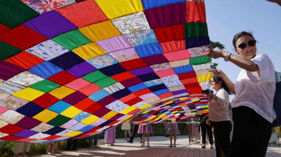 looking underneath a quilt that people are holding up high