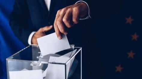 hand placing ballot in box